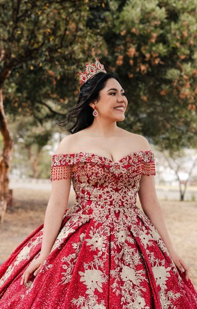 Hermoso retrato profesional de quinceaños con vestido rojo en Itchimbía Quito con naturaleza y sonrisa de felicidad