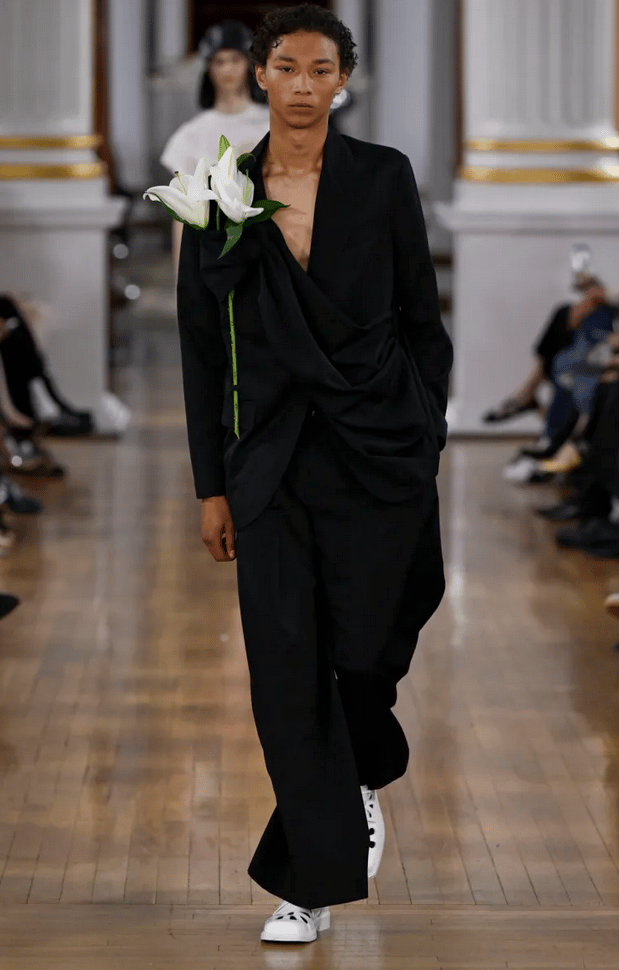 Simone Rocha model in black draped suit with floral detail on the runway at London Fashion Week 2026
