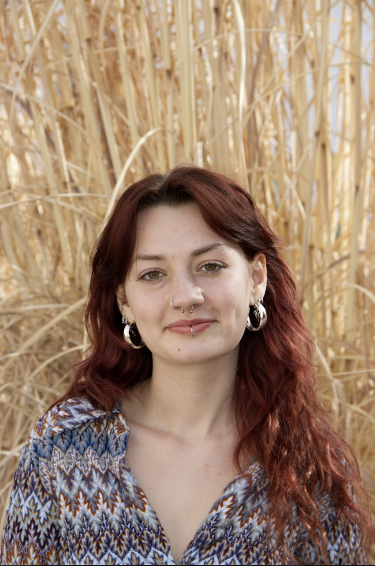 Headshot of Zinnia Crowley in a blue and maroon blouse.