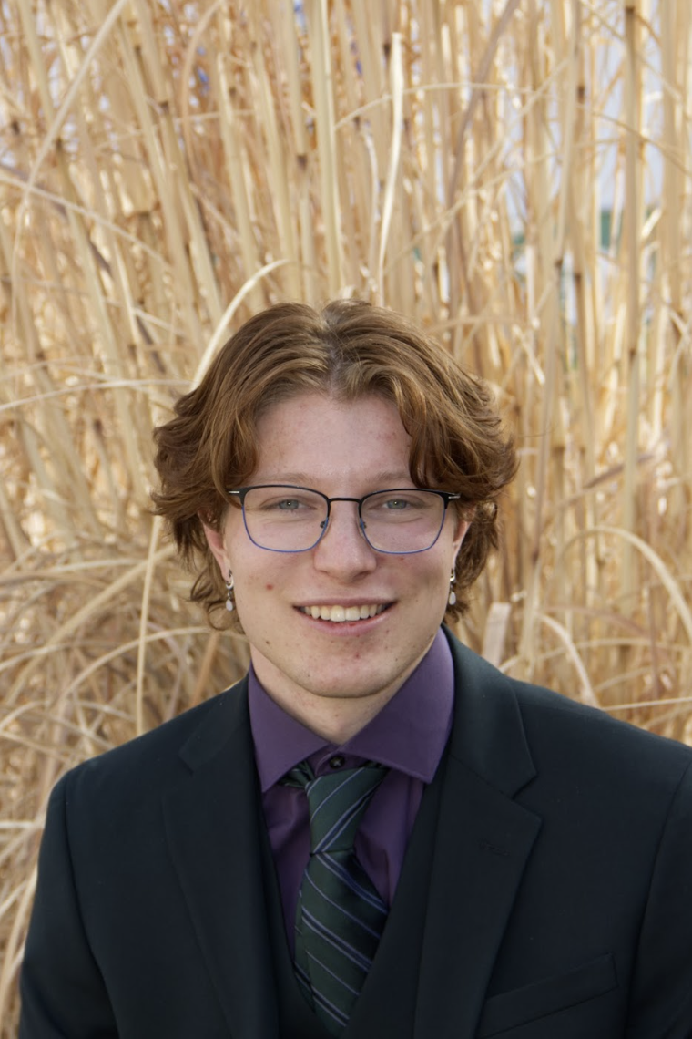 Headshot of Yishai Trowbridge in a black suit.