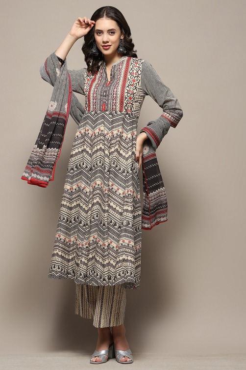 Woman wearing a grey and red printed Anarkali kurta set with dupatta and palazzo pants.