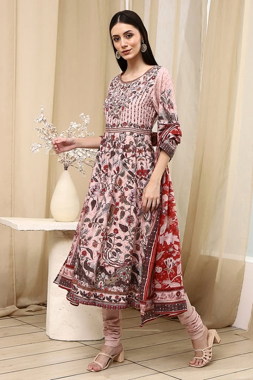 Woman wearing a floral print Anarkali kurta set with matching leggings and dupatta.