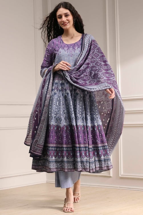 Woman wearing a purple and grey printed Anarkali suit with a matching dupatta and straight pants.