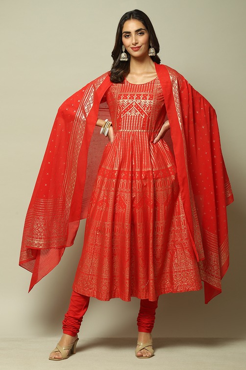 Elegant woman wearing a red and gold ethnic Anarkali suit with a matching dupatta and churidar.