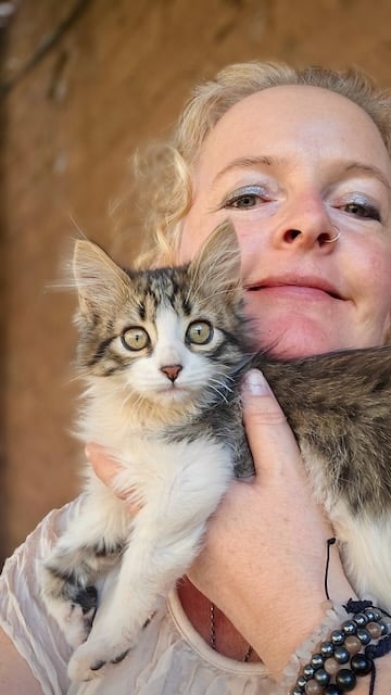 Sunni Dawson smiling with a cat companion during animal communication session