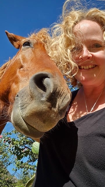 Sunni Dawson with a horse in a rural setting—reflecting intuitive connection