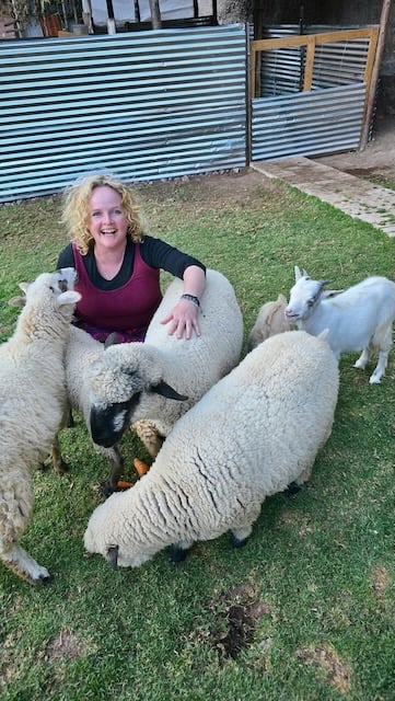 Sunni Dawson smiling with sheep and goats during animal communication session