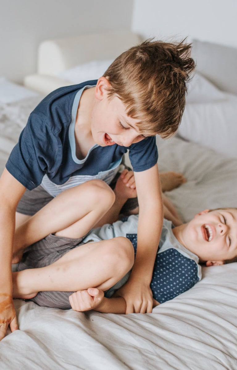 Two children play wrestling and smiling