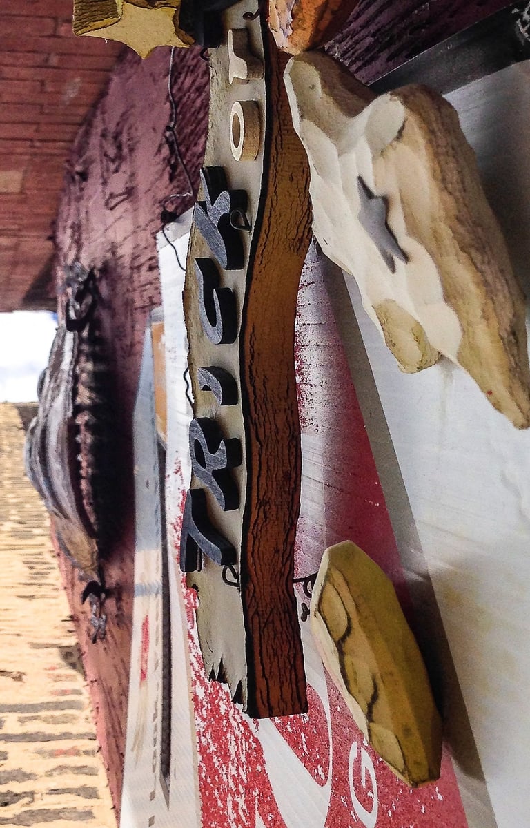 Upside down photo of a wall with several signs attached to it.