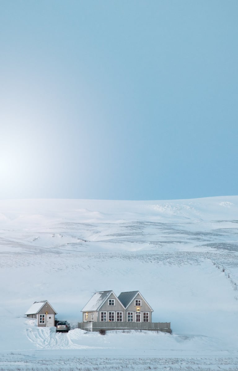 a house in the snow with a car parked in front of it