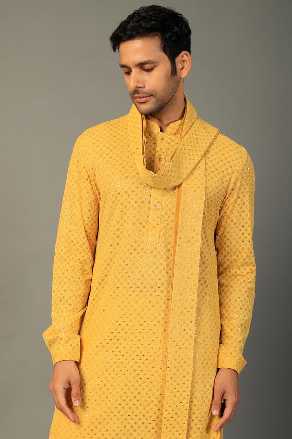 a man in a yellow jacket and tie dye on a white shirt