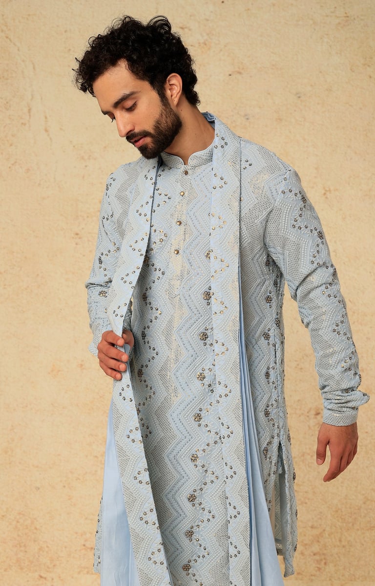 a man in a blue and white indian wedding suit