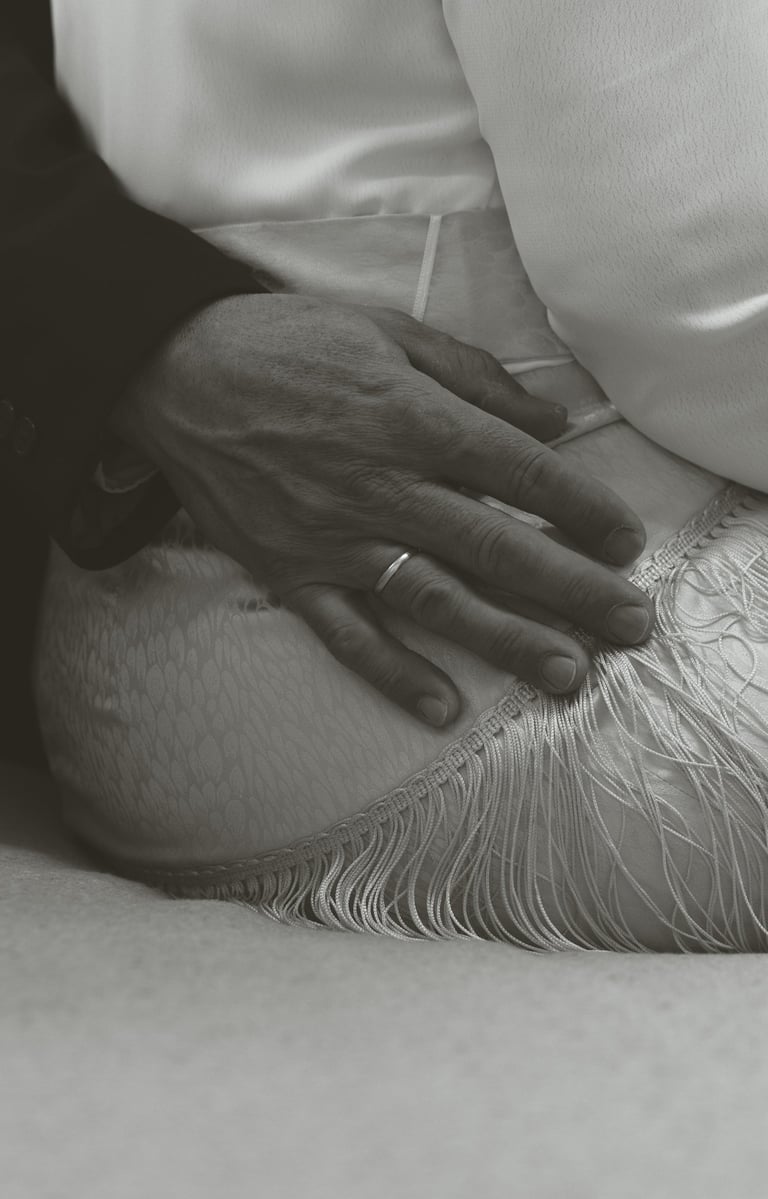 a man in a suit and tie is holding his hands on his knees
