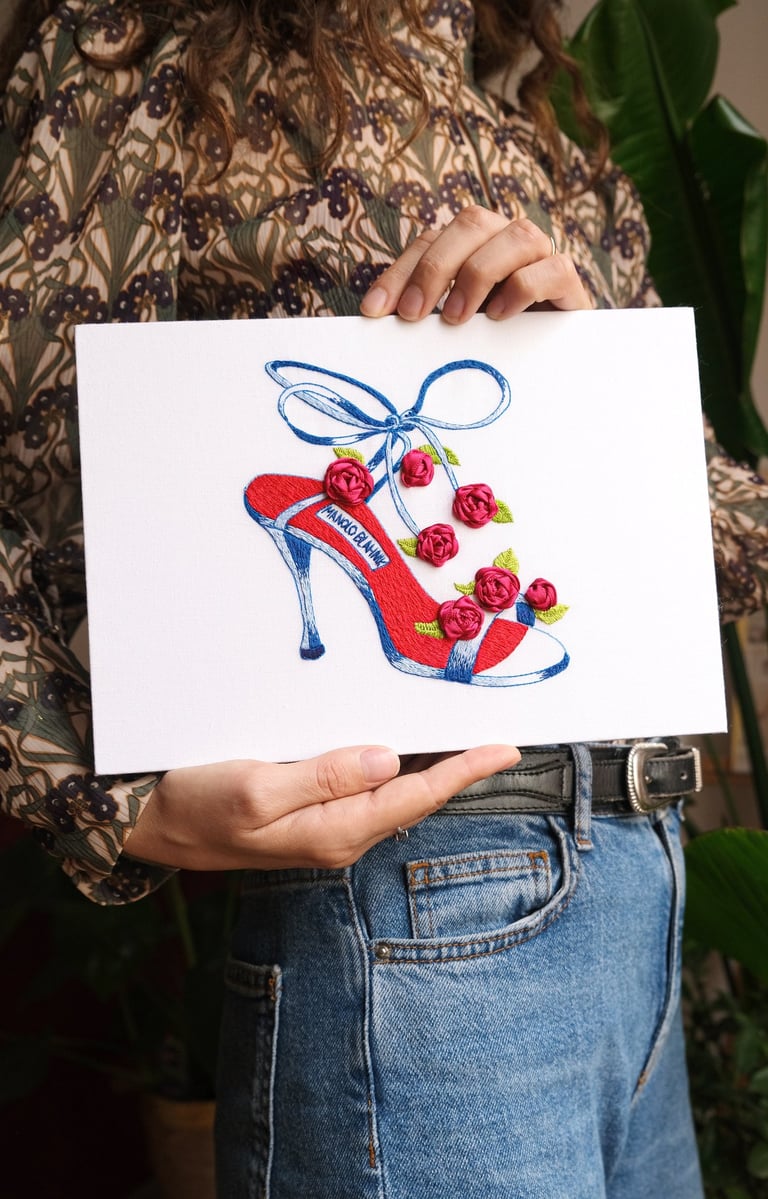 a woman holding a card with a drawing of a shoe
