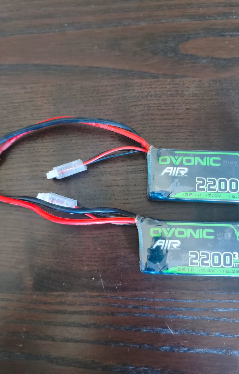 Duas baterias recarregáveis para carros RC com conectores e fios visíveis