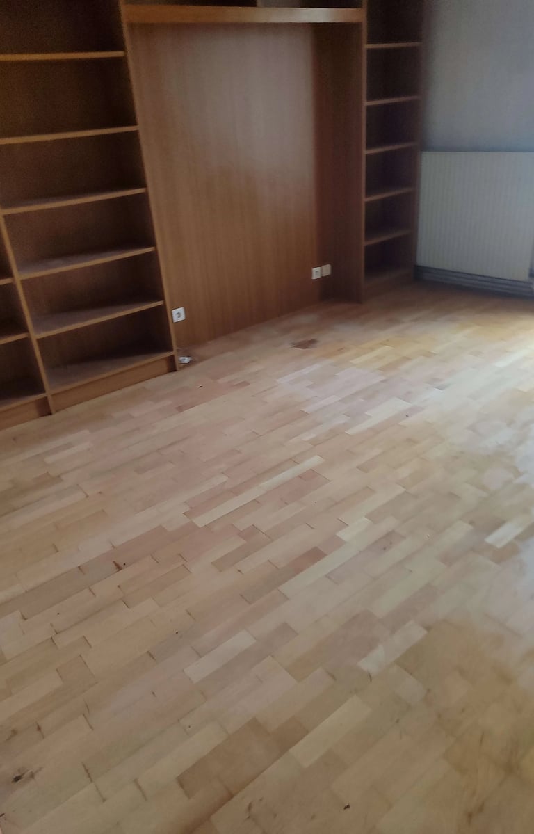 Débarras Lepeltier - Intérieur d'une pièce avec un parquet en bois et des étagères vides.