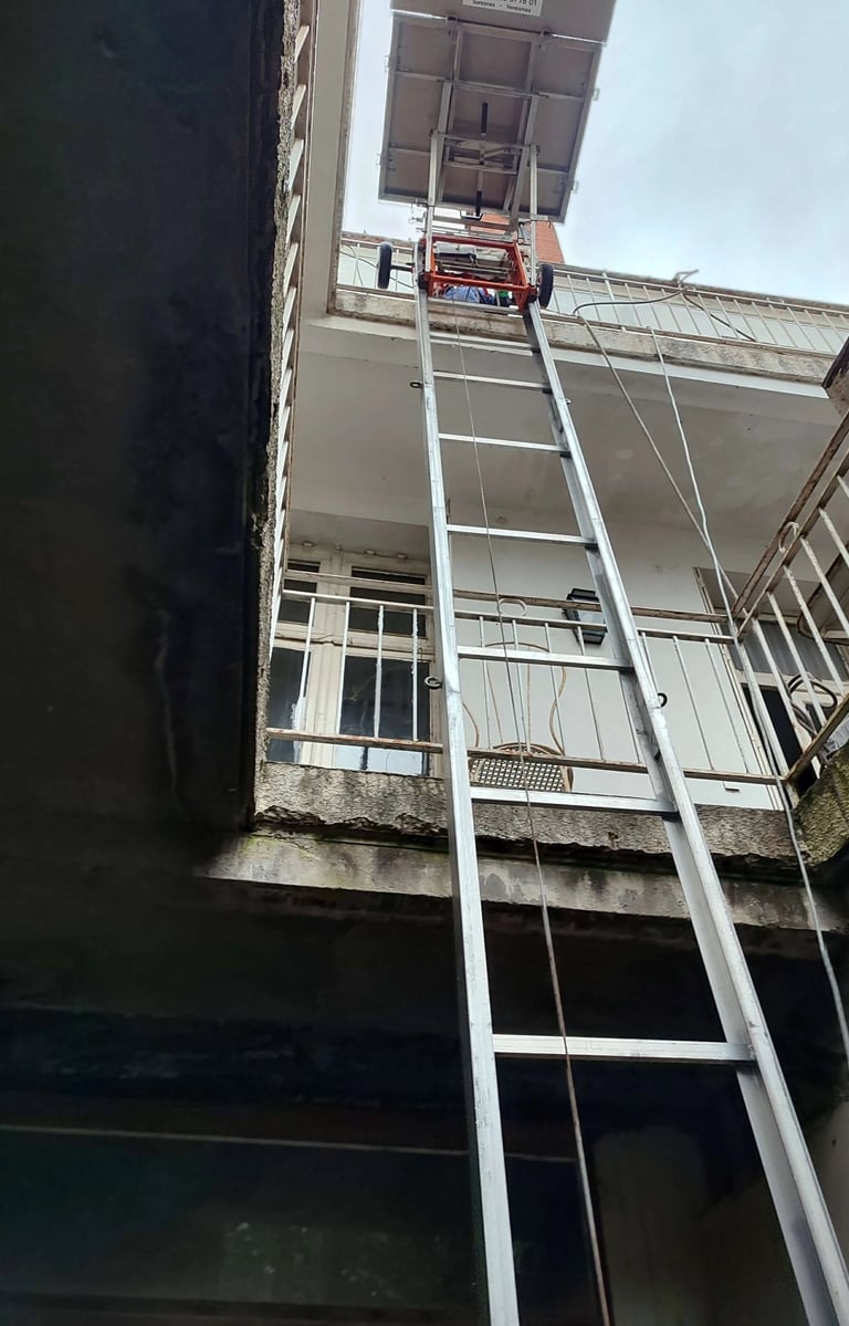 Monte-meuble Lepeltier - Chargement de meubles dans un espace étroit à ciel ouvert.