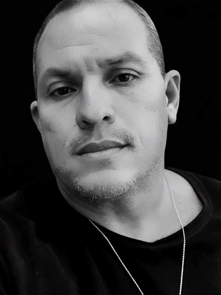 a man with a necklace and a necklace with a star on it