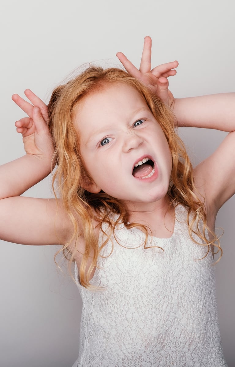 a young girl with blonde hair and a white top