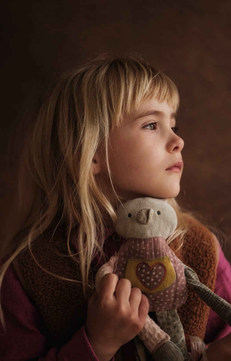 a young girl holding a stuffed animal