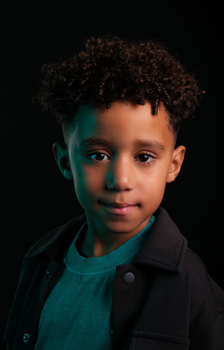 a young boy with a black jacket and a green sweater