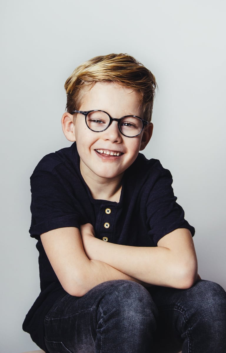 portret of a young boy with glasses and a black shirt