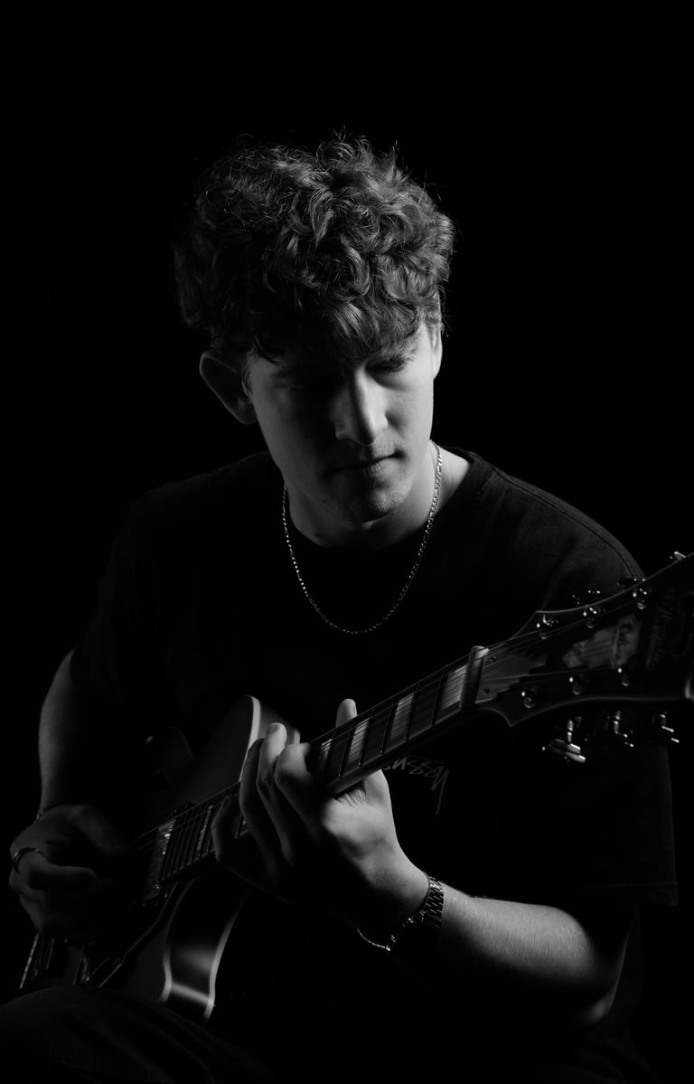 portrait of a man playing a guitar in a black and white photo