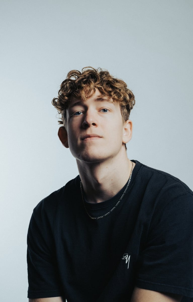 portrait of a man with curly hair and a black shirt