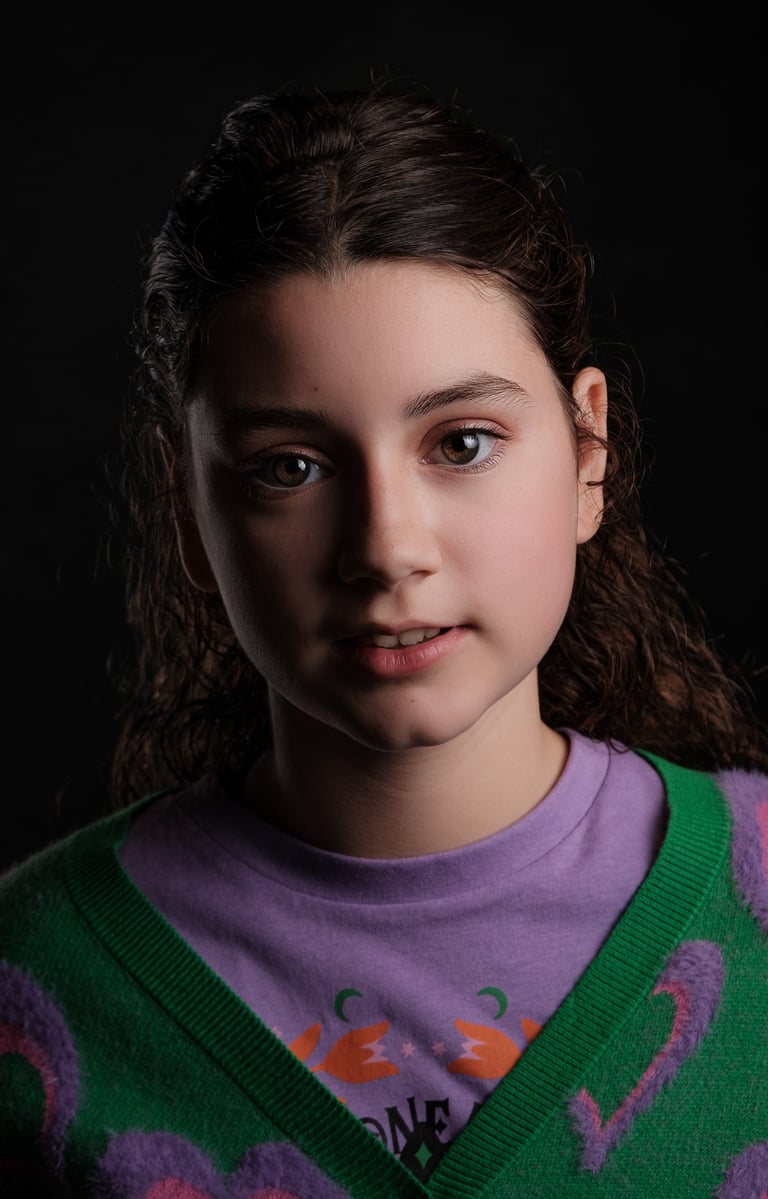 a young girl with a green sweater and a purple sweater