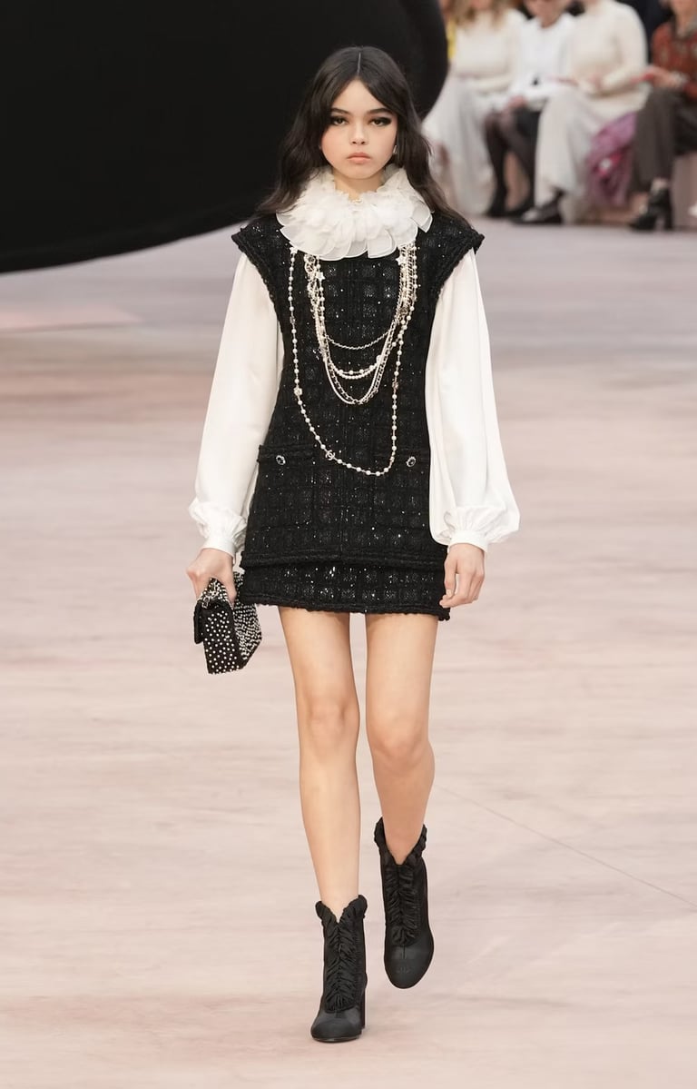 Black and white tweed mini dress with pearl necklaces at Chanel FW25/26.