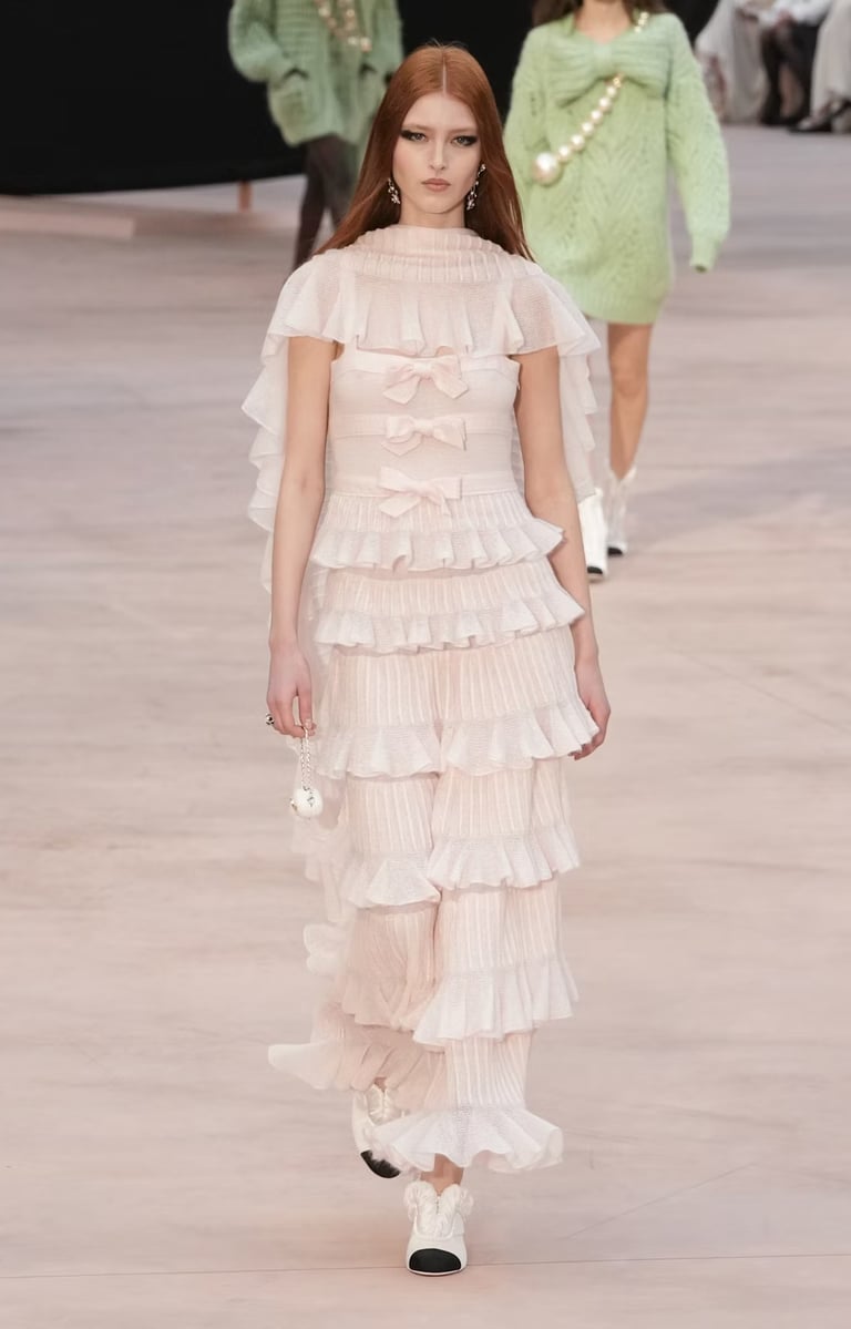 Model in pastel ruffled gown with layered bows from Chanel FW25/26.