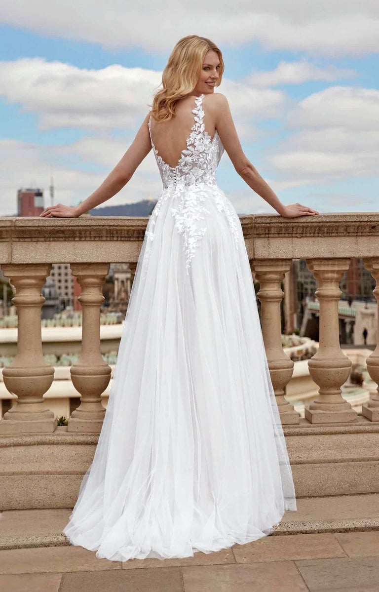 a woman in a white dress standing on a balcony