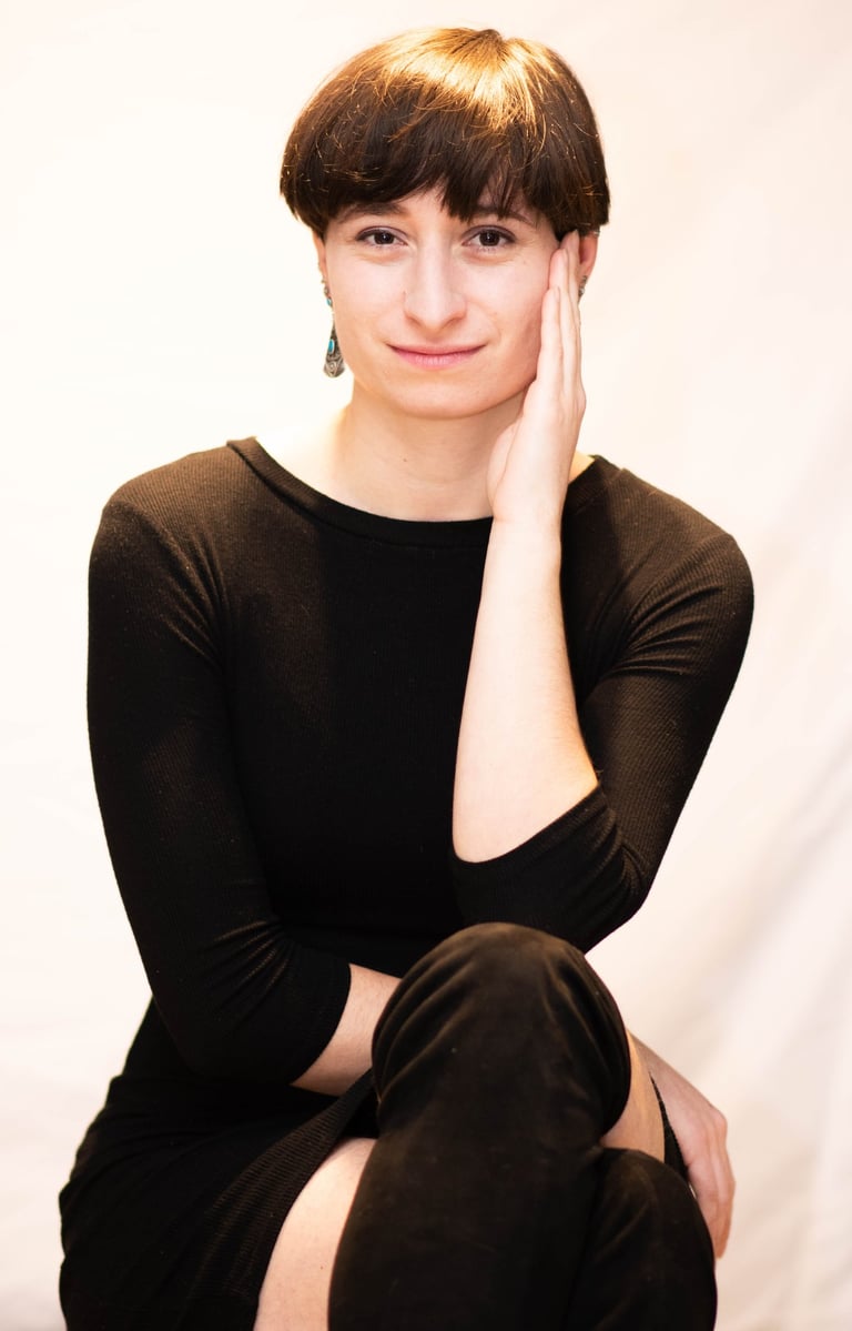 Une femme élégante posant assis devant un fond blanc lors d'une séance photo en studio