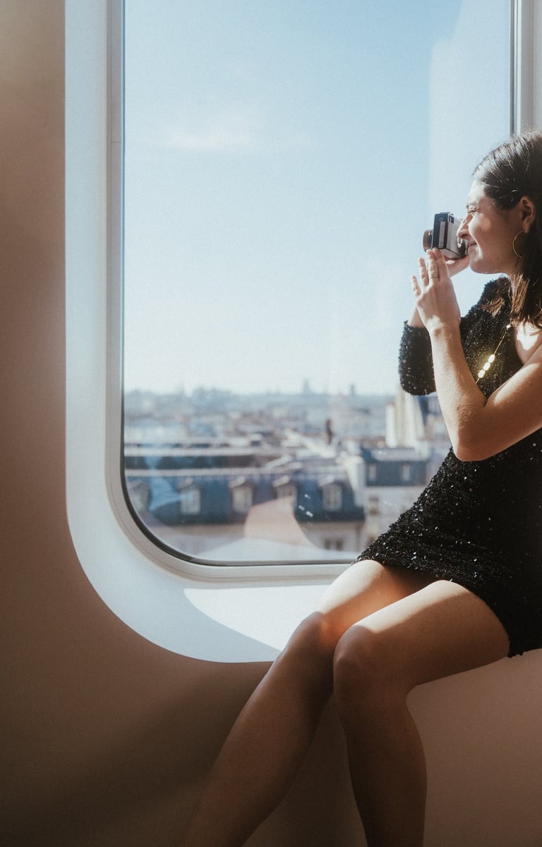 Femme qui prend des photos depuis sa chambre de l'hôtel Renaissance Paris République