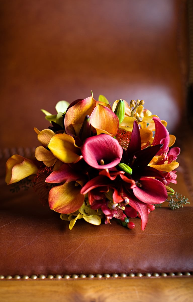 beautiful fall colored bouquet sitting on leather chair