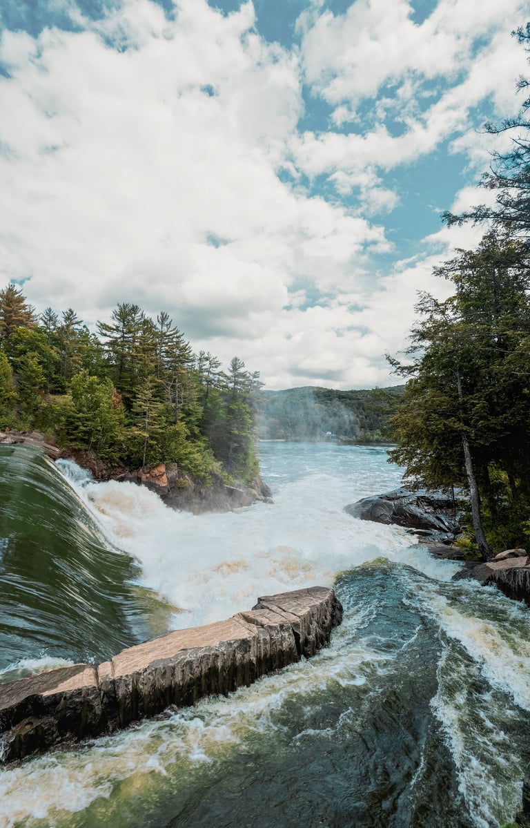 a river with a waterfall and a bridge
