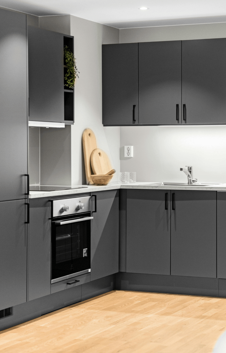 Reforma de cocina en Valencia con diseño moderno en tonos grises y encimera de mármol.