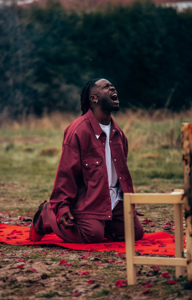 a man, Jok'Air, sitting on a blanket on a blanket