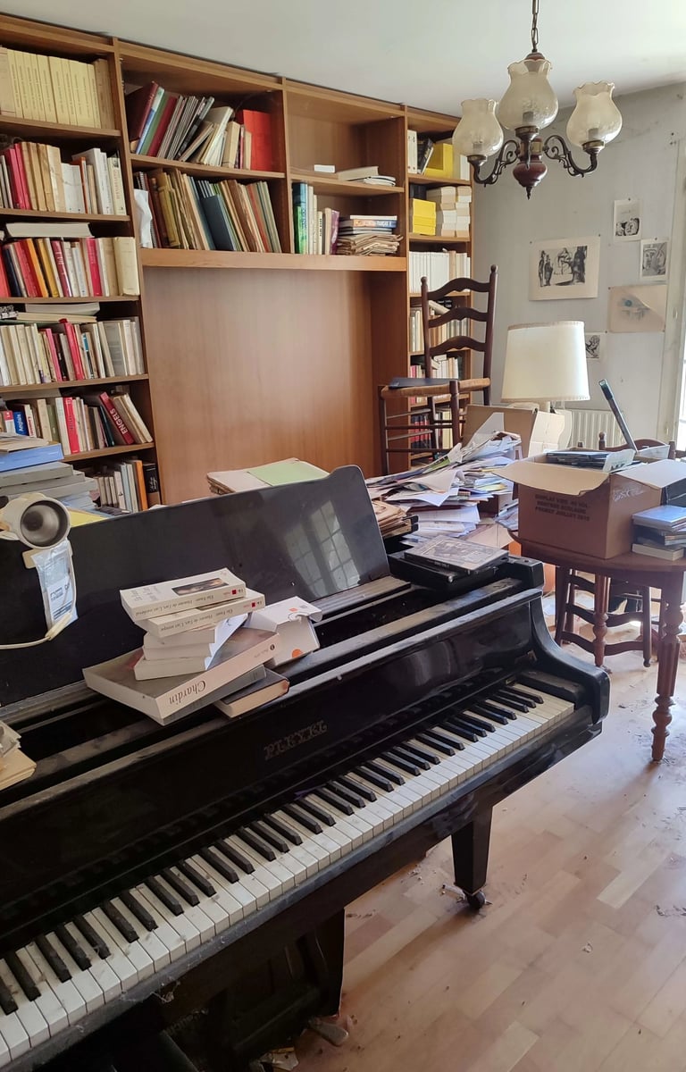 Débarras Lepeltier - Un piano noir élégant placé dans une pièce lumineuse avec des murs clairs et un sol en bois.
