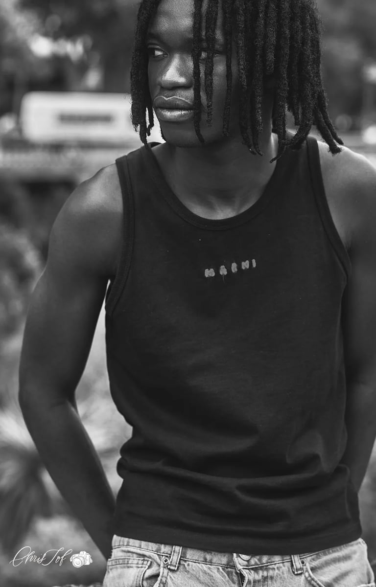 Portrait en noir et blanc d'un jeune homme avec des dreadlocks portant un débardeur à Perpignan 66.