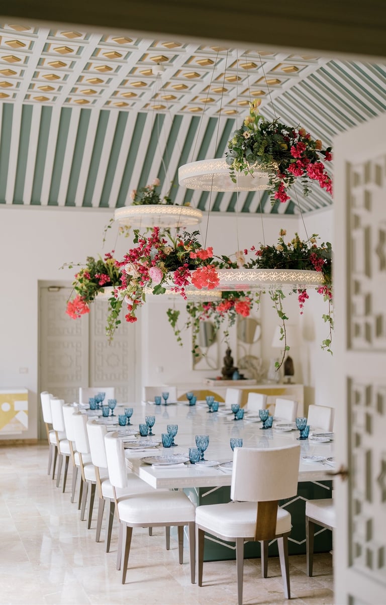 Dining room at Villa El Rincon featuring ornate ceilings with hanging lights and floral decorations for a destination wedding
