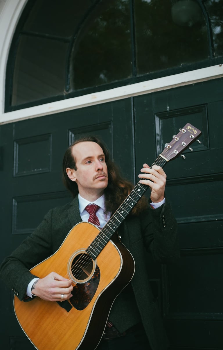 a man in a suit and tie playing guitar