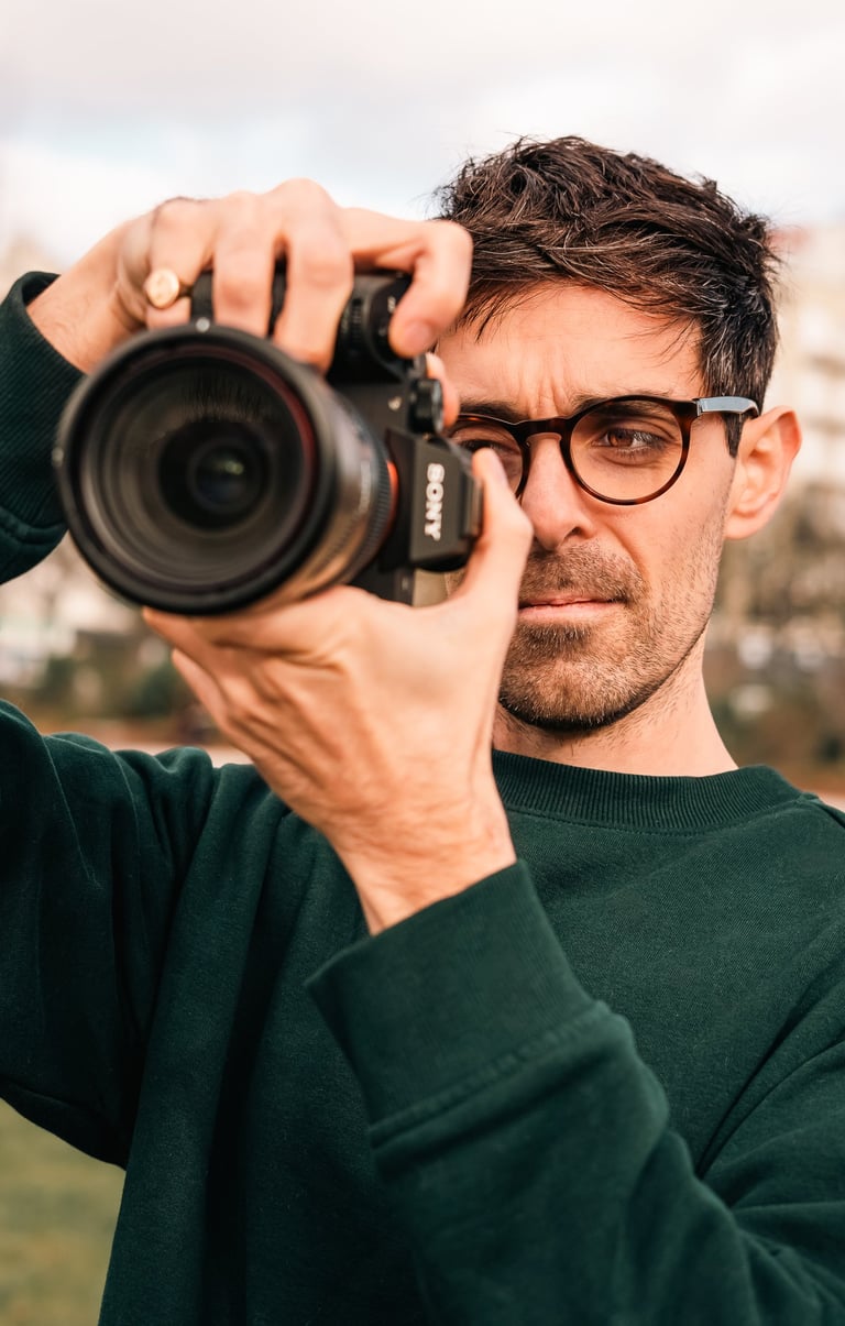 Photographe tenant son appareil photo lors d’une prise de vue, portrait naturel