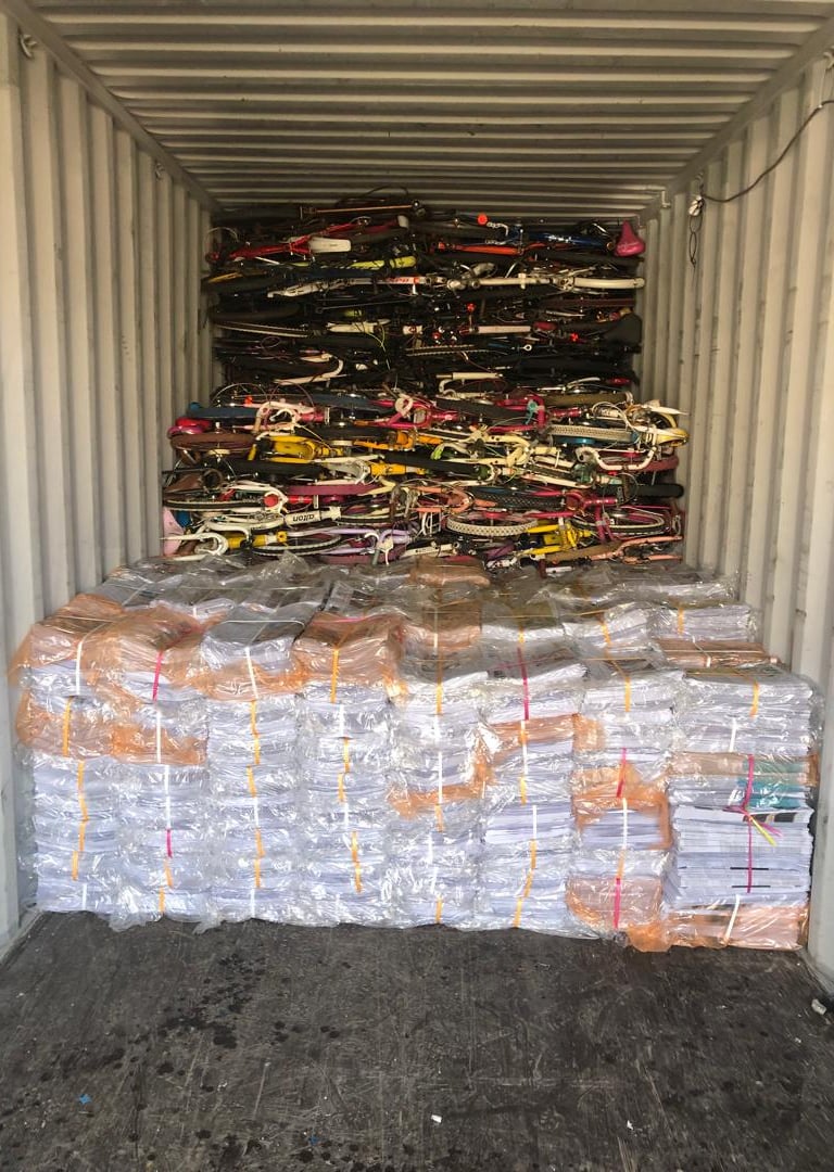 over issued newspaper  and used bicycles loaded in a container for export to Afghanistan