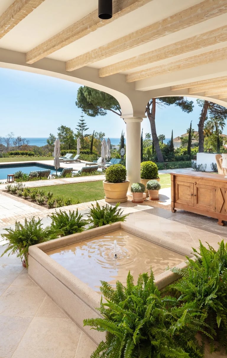 Covered terrace with fountain, pool and sea views