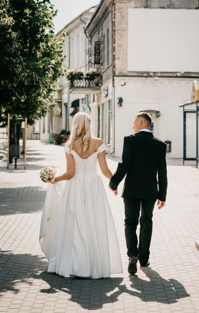 a bride and groom walking down the street