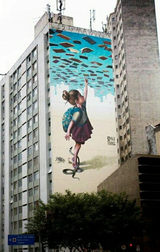 Detalhe de um mural de grafite mostrando rostos expressivos e cores vivas