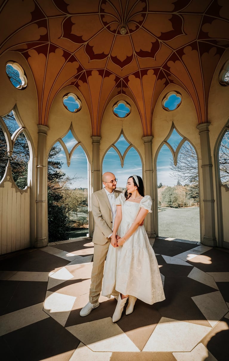 Couple holding hands inside an ornate pavilion in Painshill Park, captured by Fred Art Studio.