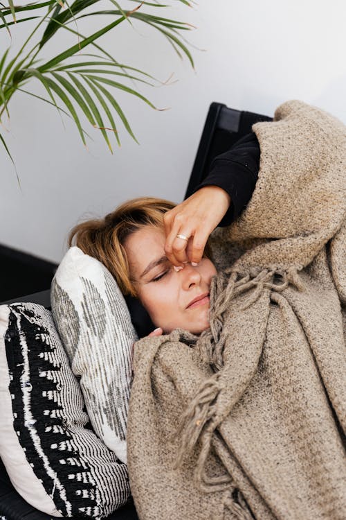 a woman in a blanket on a couch