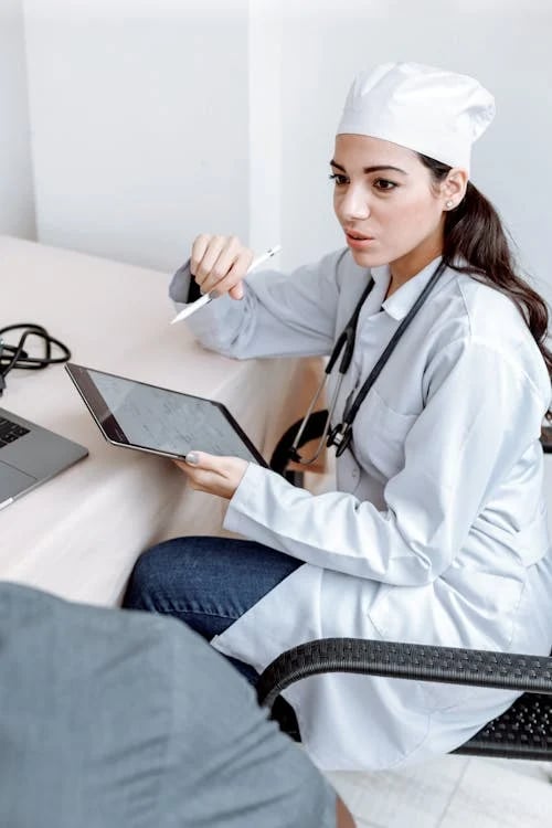 a woman doctor in a white coat and a laptop